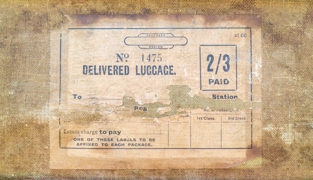 A photograph of a vintage luggage tag.