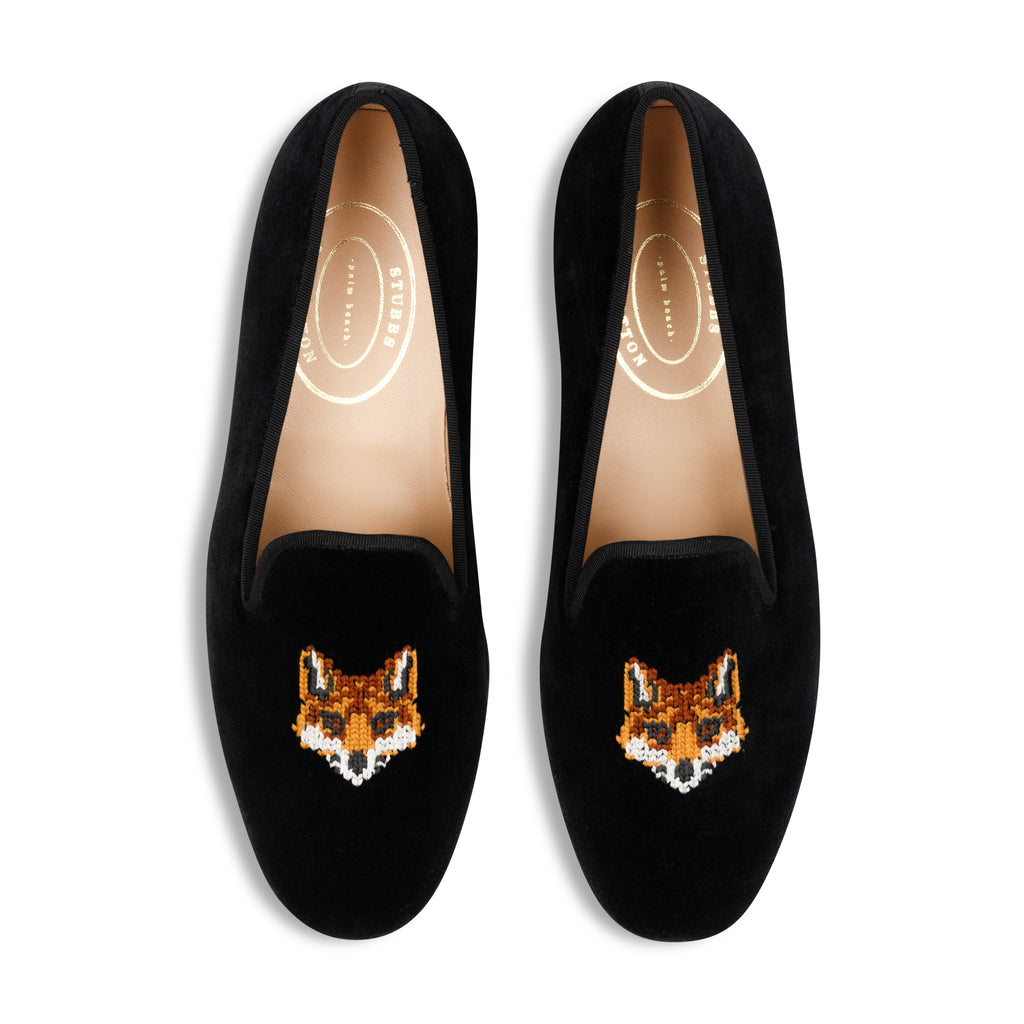 Black loafers with fox embroidery on a white background