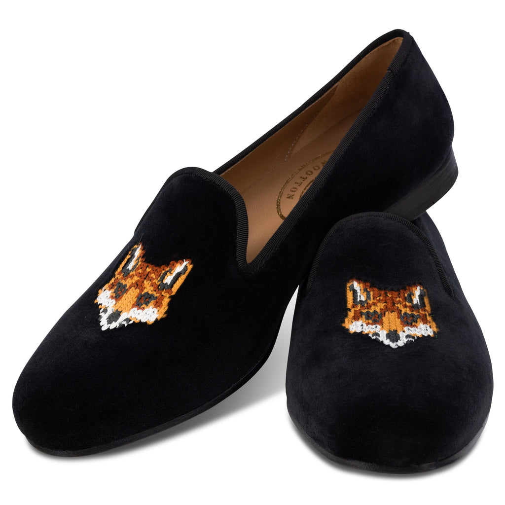Black loafers with fox embroidery on a white background