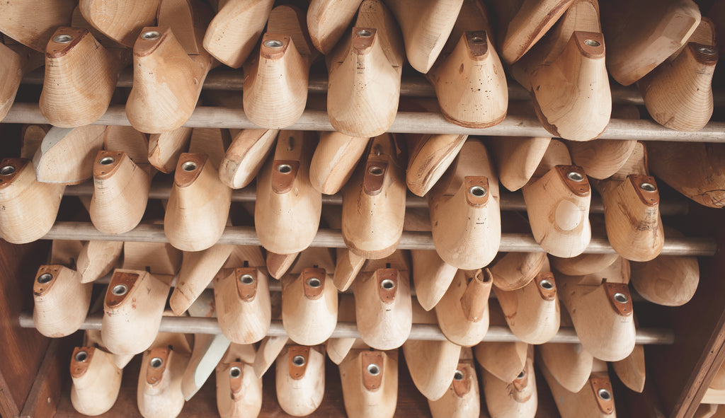 A photograph of shoe molds lined up on shelves.